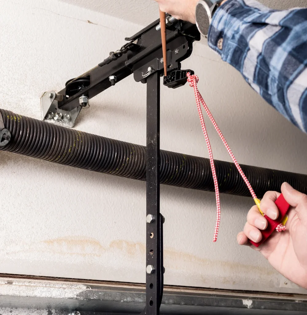 Person adjusting garage door mechanism