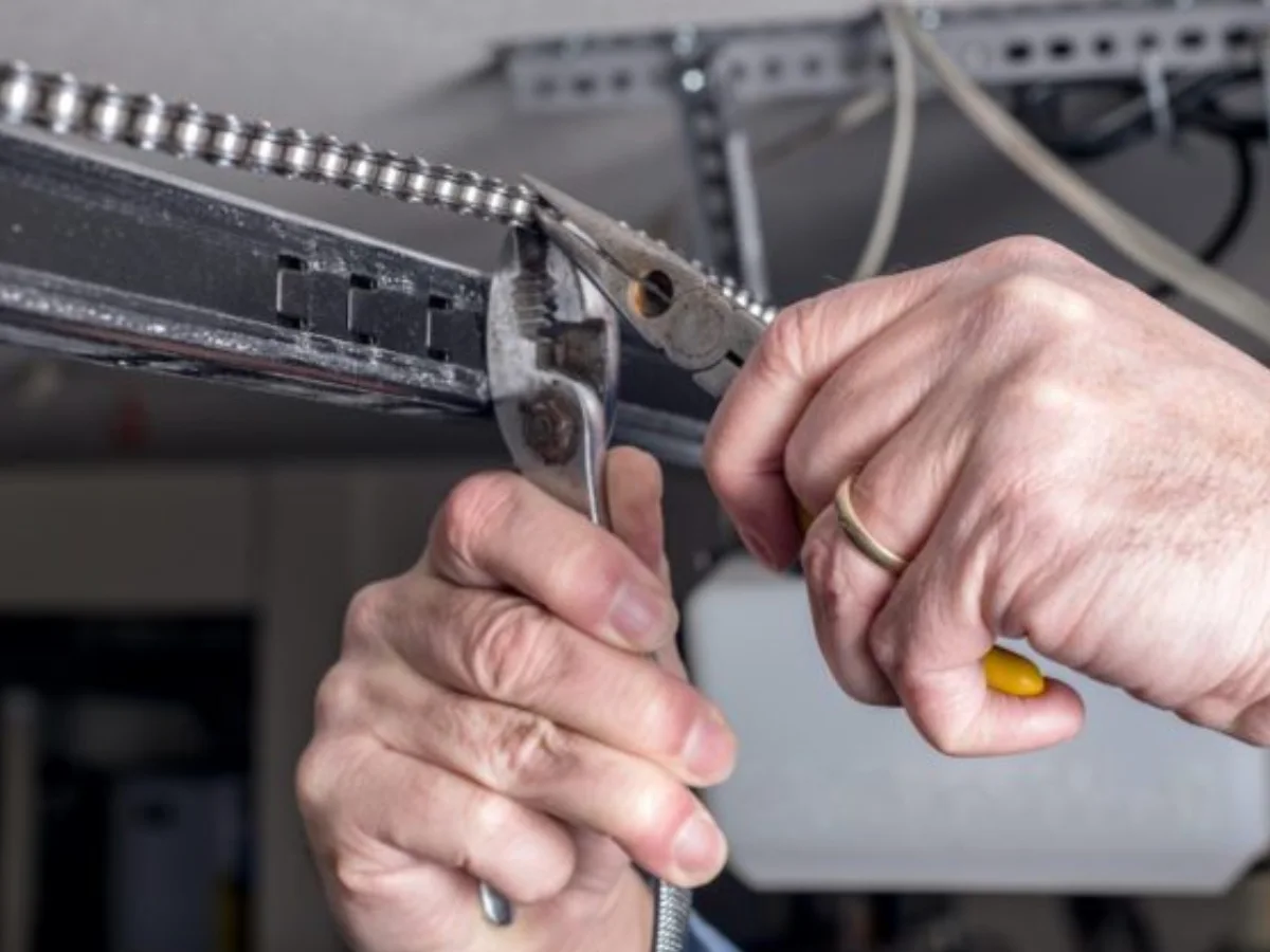 Person repairing garage door mechanism